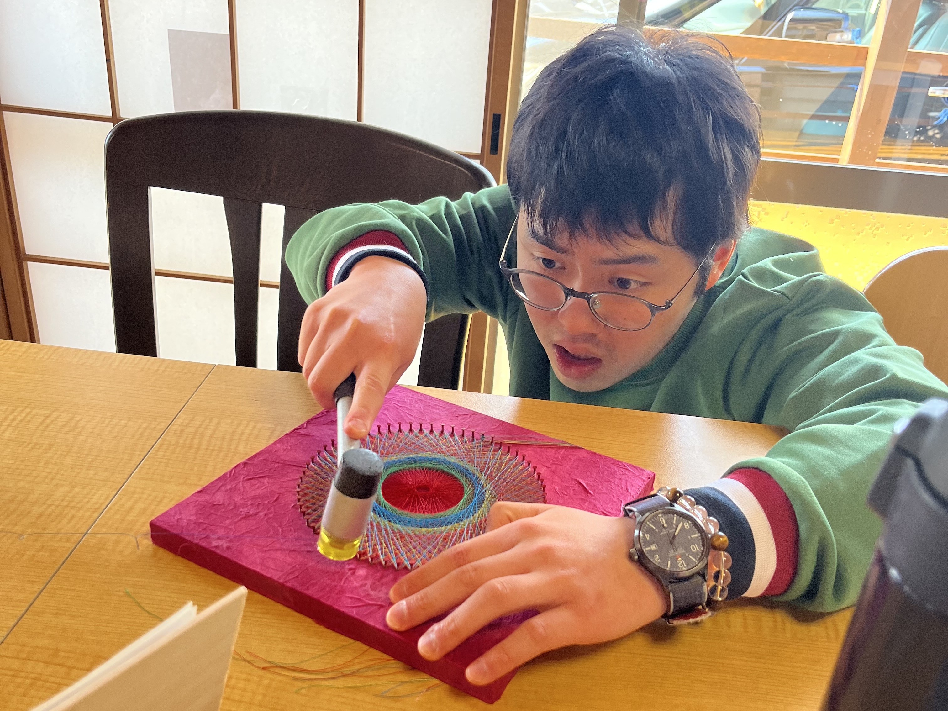 この商品を手がけたのは、「やまとあい」を利用する糸かけ職人、星 佳佑(ほし けいすけ)さんです。
作品のサイズは職員がアドバイスしますが、色合いや糸の掛け方は星さん自身が決めるという強いこだわりがあります。その集中力と個性が生み出した、唯一無二の曼荼羅アートです。
星さんは一閑張りの制作を通じて「これは僕の作品です」と自らの口で言えるほどの大きな自信をつけました。
完成:令和7年7月